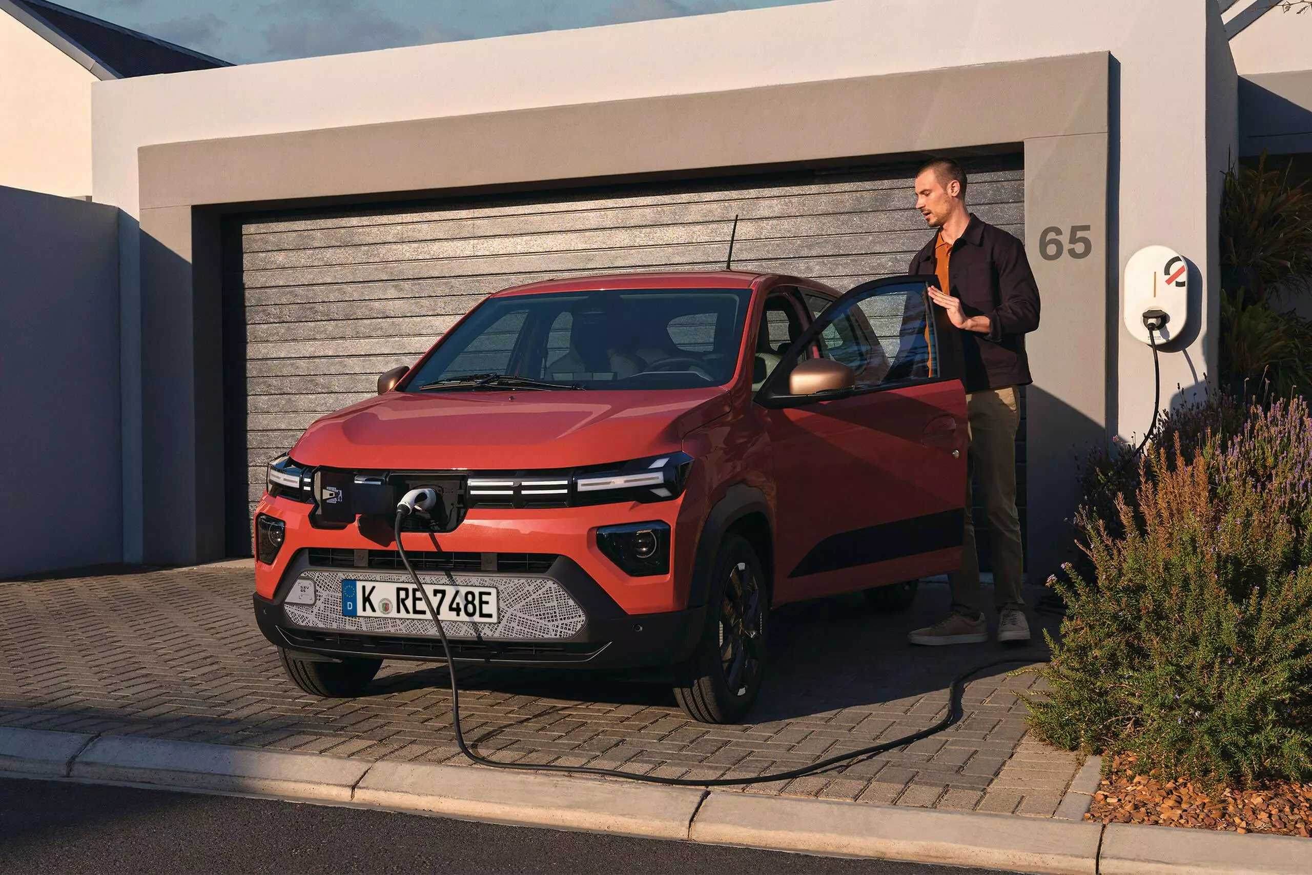 Dacia Spring lädt vor Garage auf