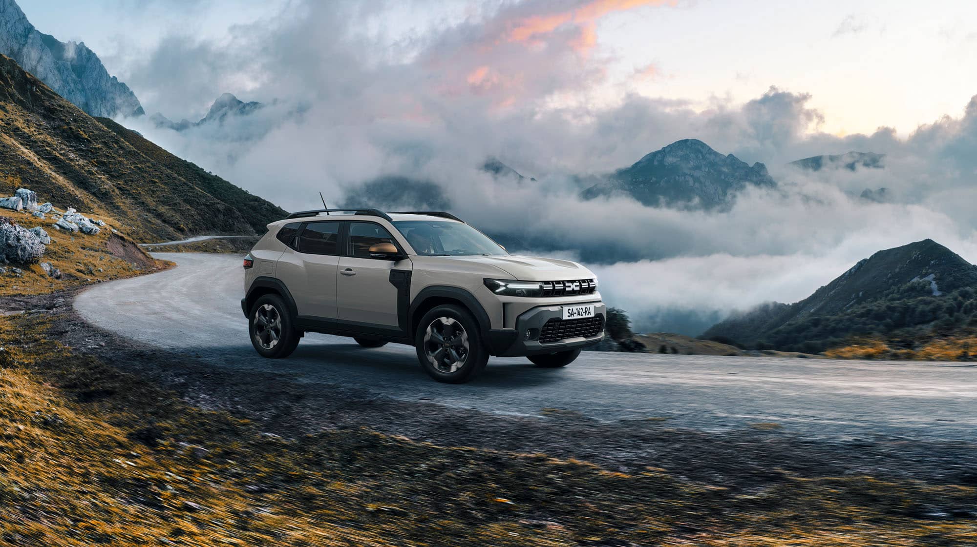 Der Dacia Duster auf Gebirgsstraße vor tiefliegenden Wolken bei RRG.